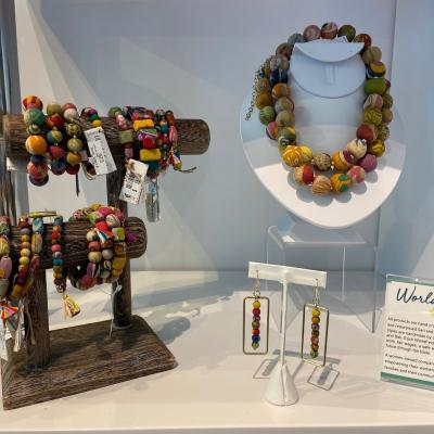 colorful beaded bracelets, a necklace, and earrings on display at the Shop