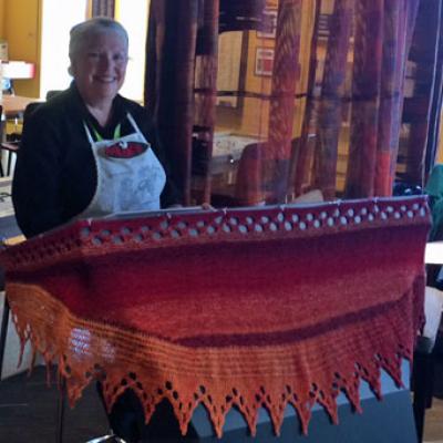 Margaret Charlton and the shawl she knitted for the touch table in the Thread Studio