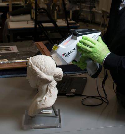 Staffer using tool to clean head of Apollo statue