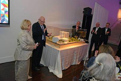 Sherry and Lanny Martin receiving a round of applause while standing next to the model of the art museum