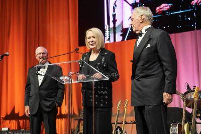 Jana and Fred Bartlit speaking on stage at a podium