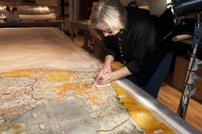 Speaker at the Denver Art Museum's Insight program consolidating flaking gold paint