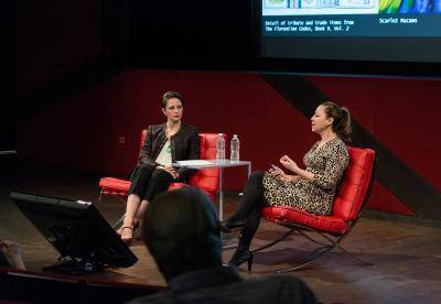 Two women in conversation on stage at a museum lecture
