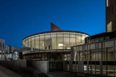 Nighttime outside view of the circular Sie Welcome Center structure