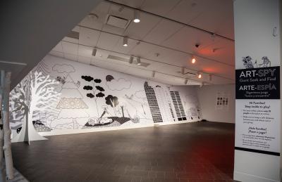 Instruction sign and mural for the Art Spy: Giant Seek and Find game in the galleries