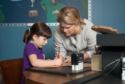 Woman checking the work of young girl