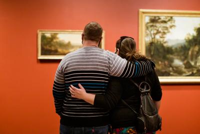 Couple embracing while gazing at paintings