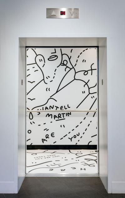 black and white drawings and words in the inside of an elevator at the museum