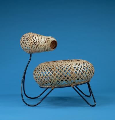 A round woven bamboo chair, stretched over a minimalist iron frame.
