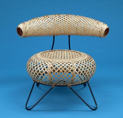 A round woven bamboo chair, stretched over a minimalist iron frame.