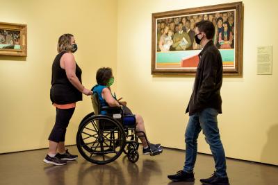 Visitor in wheelchair looking at art