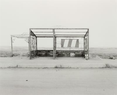 Old photo of a bus stop in a remote area.