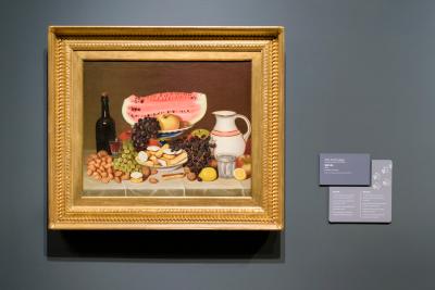 painting on a wall with the label and paw print stickers signifying it's one of the stops for the family game in the exhibition