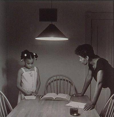 Black and white photoof an African American woman talking to her daughter at the kitchen table