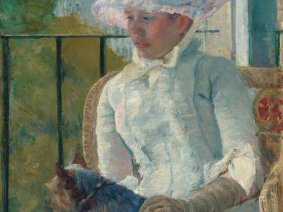 Young girl sitting at a window with her dog in her lap.