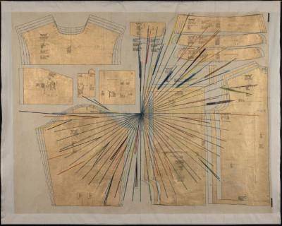 Gold-colored garment pattern pieces across a muslin canvas that correspond to different areas of the body: a collar, a tunic, and a back panel. An Inka khipu lays overtop; its knotted cords spread radially around the center just shy of making a full circle.