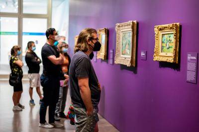 Group of visitors looking at a wall of art