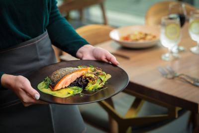 Chef holding a plate of salmon