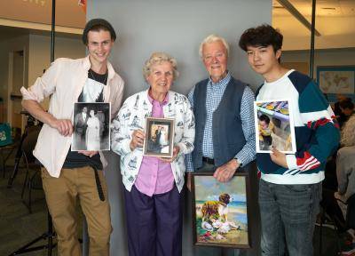 4 people holding photos, from left is a college-age man, then an older woman, then an older man, then a college-age man