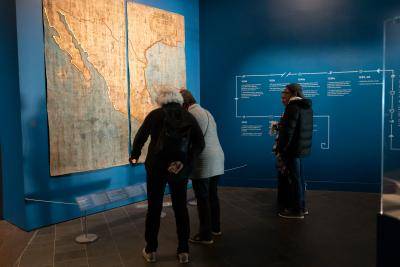Group of visitors examining a large map inside the La Malinche exhibition