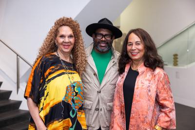2 women and 1 man stand side by side in the atrium at the DAM