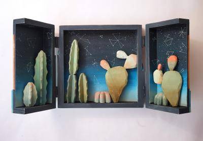 A diorama triptych featuring cut outs of cacti and the night sky