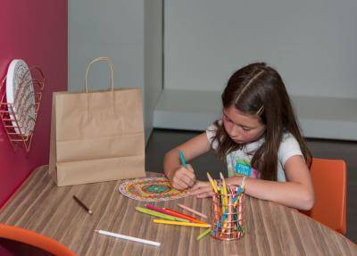 girl coloring a mandala coloring page