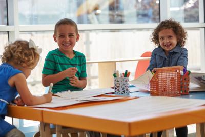 3 kids at a table coloring