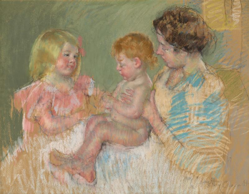 A mother with her young daughter and infant on her lap.