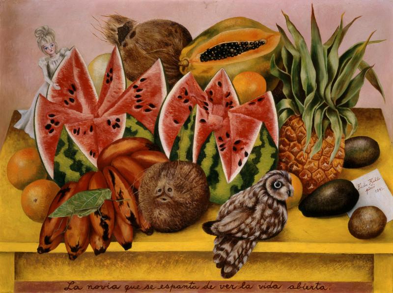 a cut open watermelon and coconut, papaya, and pineapple. on the right of the watermelon a small woman dressed in white looks into the watermelon