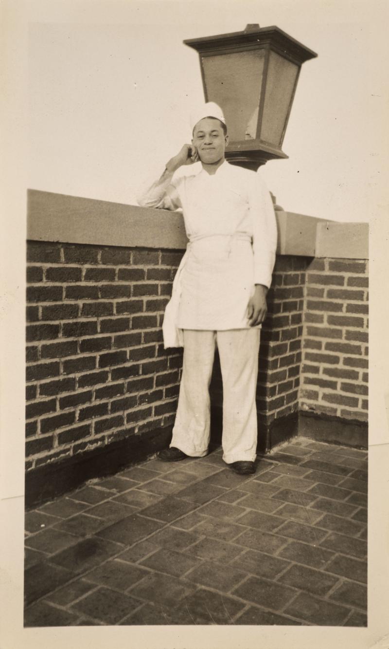 a man in kitchen uniform and apron on top of the roof