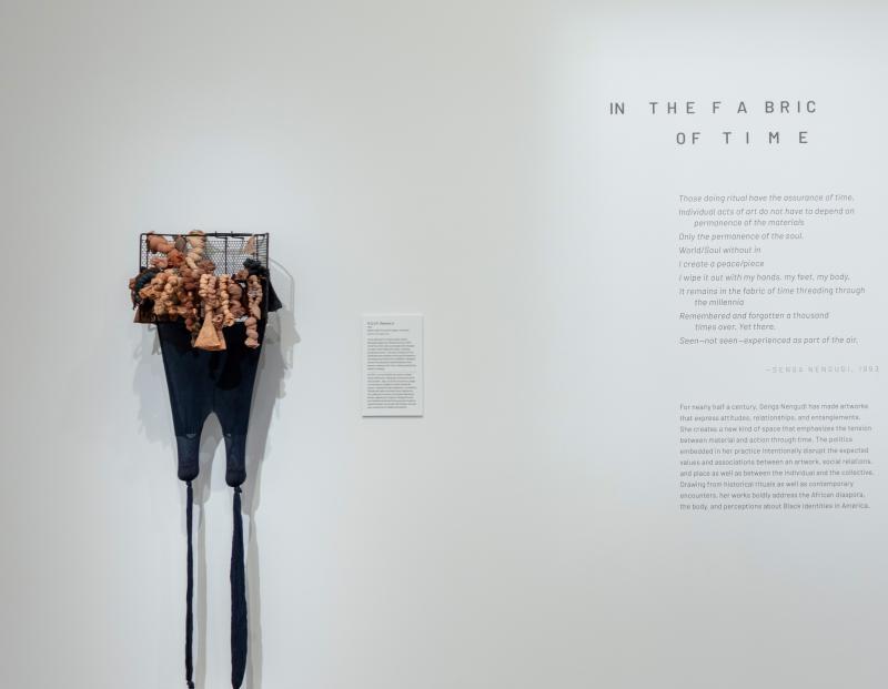artwork made of stockings and a writing by Senga Nengudi on a gallery wall