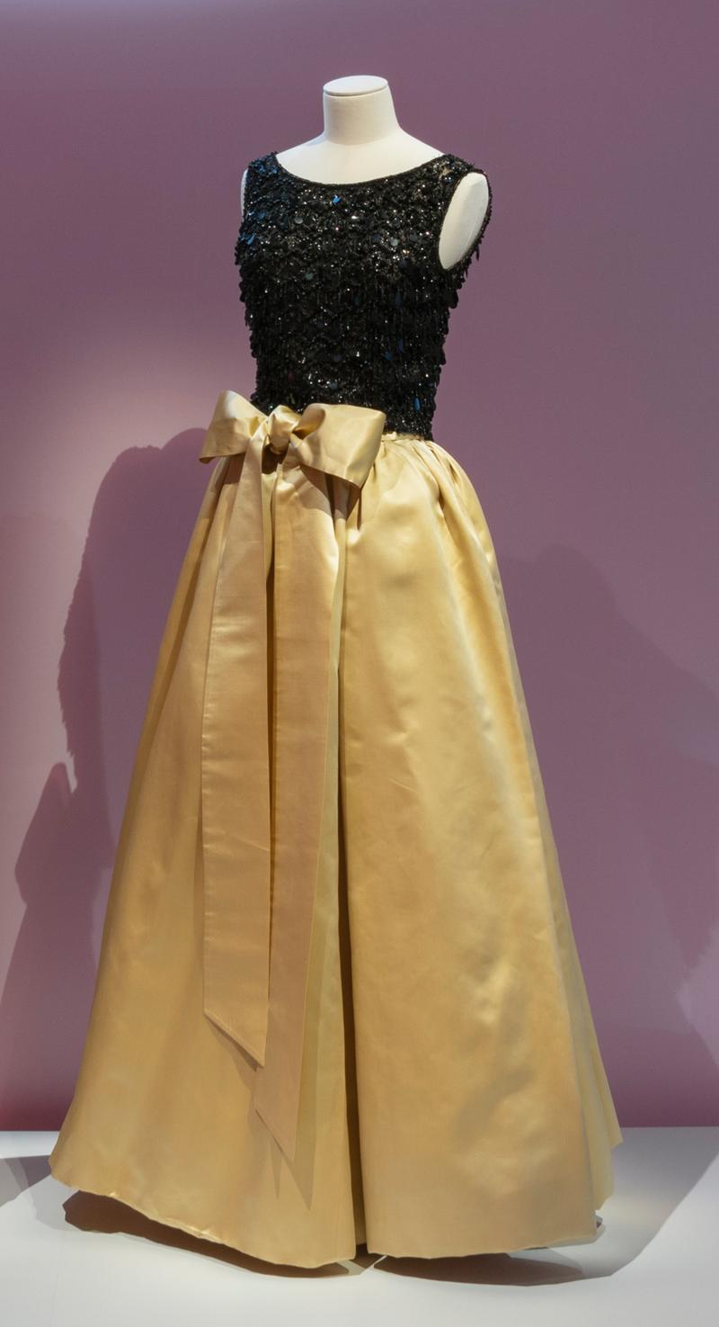 evening dress with black sequined top and long gold skirt displayed in the exhibition