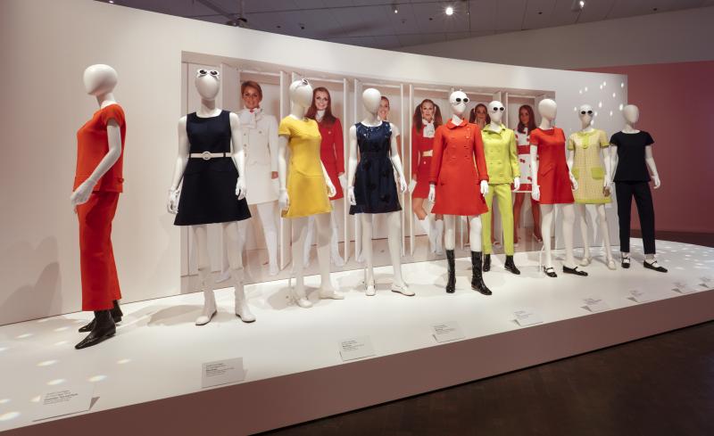 Photograph of part of the exhibition that features nine mannequins in bold and bright outfits designed by André Courrèges.