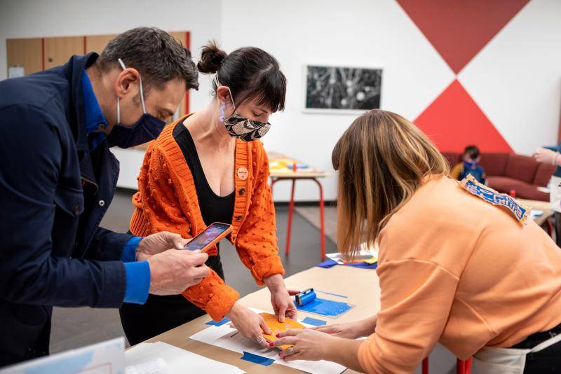 Adults huddled over an arts and crafts table