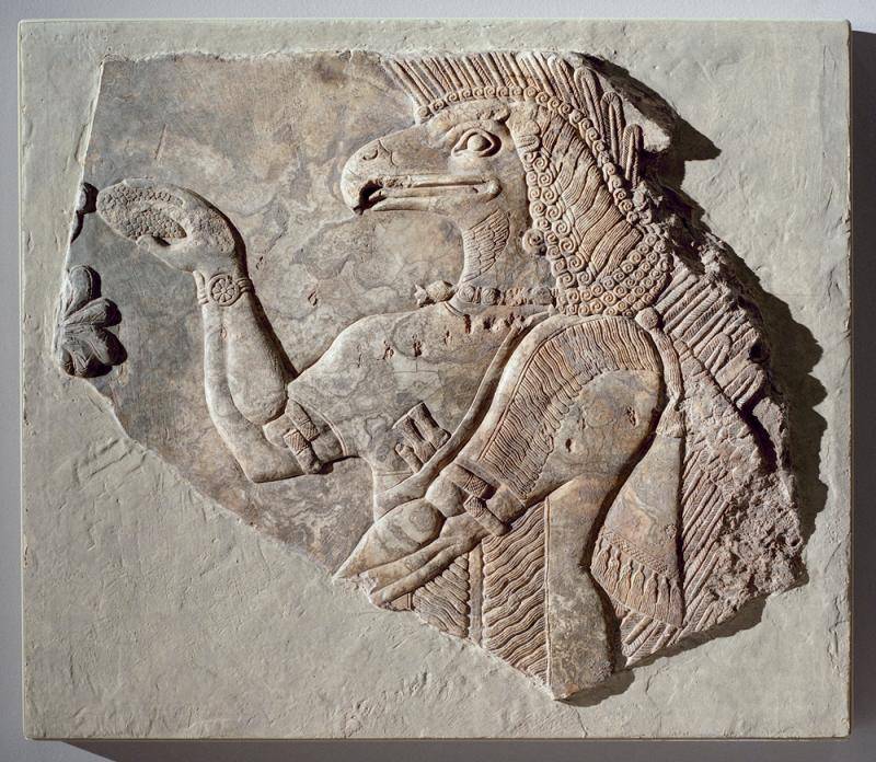 Anicent stone carving of a bird-headed god-like figure.