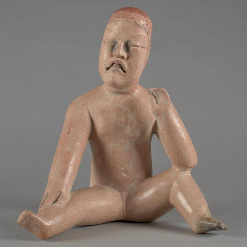 Sculpture of a seated baby with a hollow body.