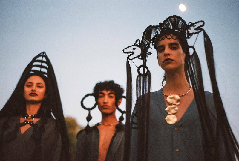 Three models dressed in headpieces designed by Carla Fernandez
