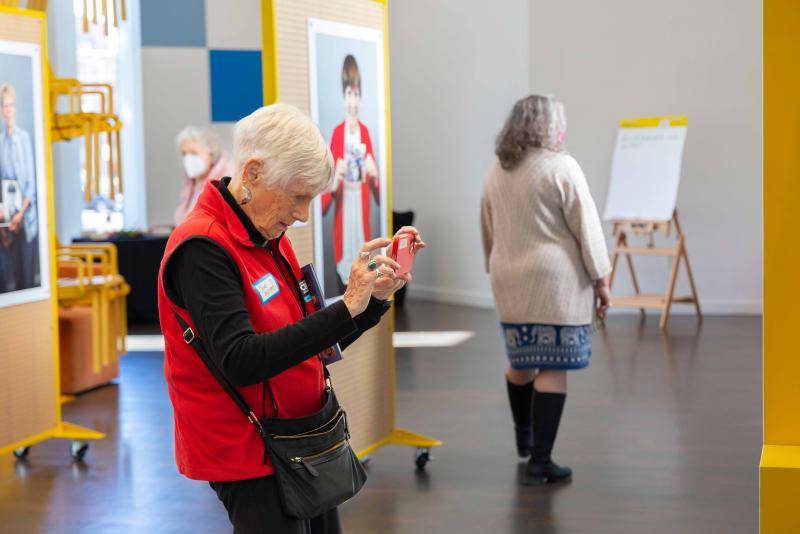 An older woman taking photos inside the exhibition