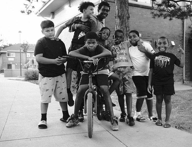 Black and white photo of a group of neighborhood kids posing for the camera