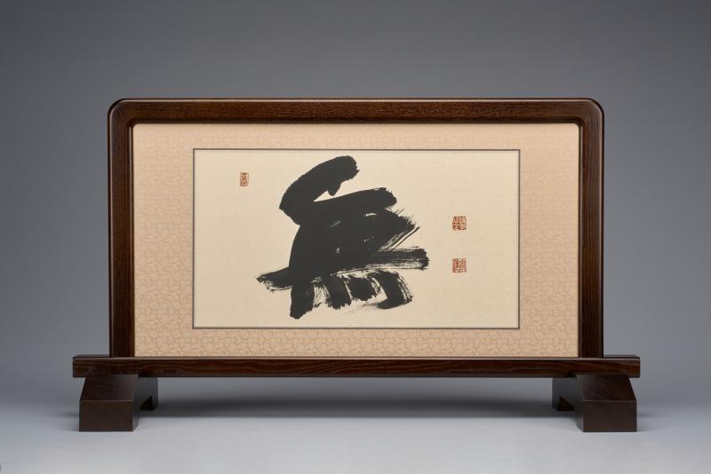 Ink on paper calligraphy encased in a table screen with a wooden frame