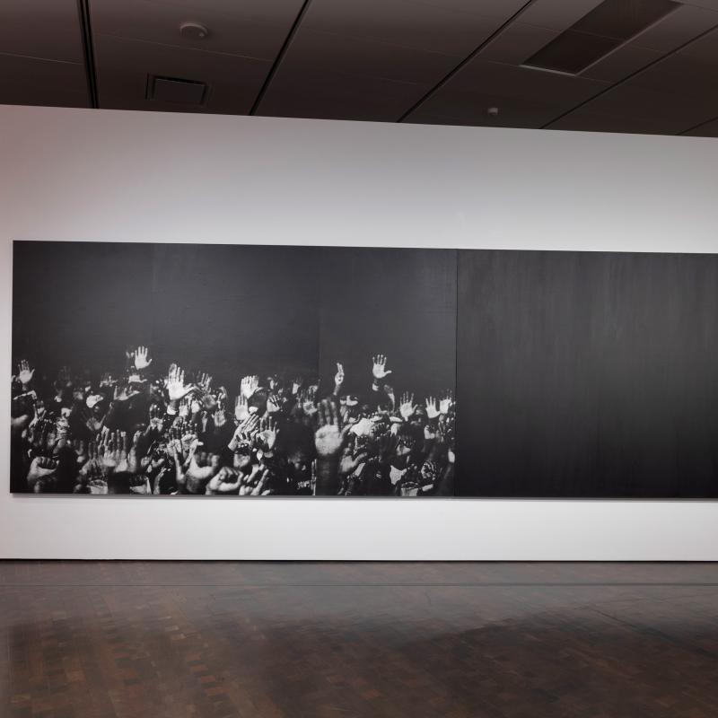 'Hands (Diptych)' by Glenn Ligon, black and white photograph of hands reaching upwards, with a fully black panel next to it. 