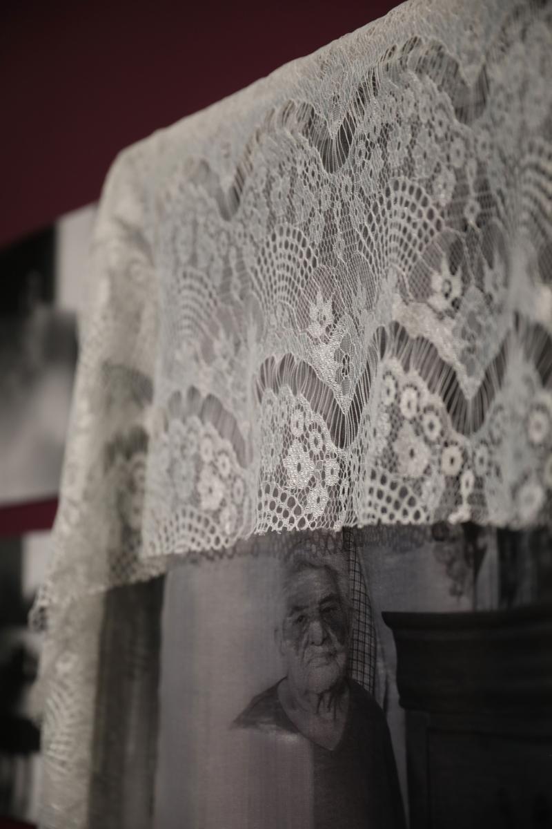 Mixed media installation of a cloth with a photograph of an older man embroidered within