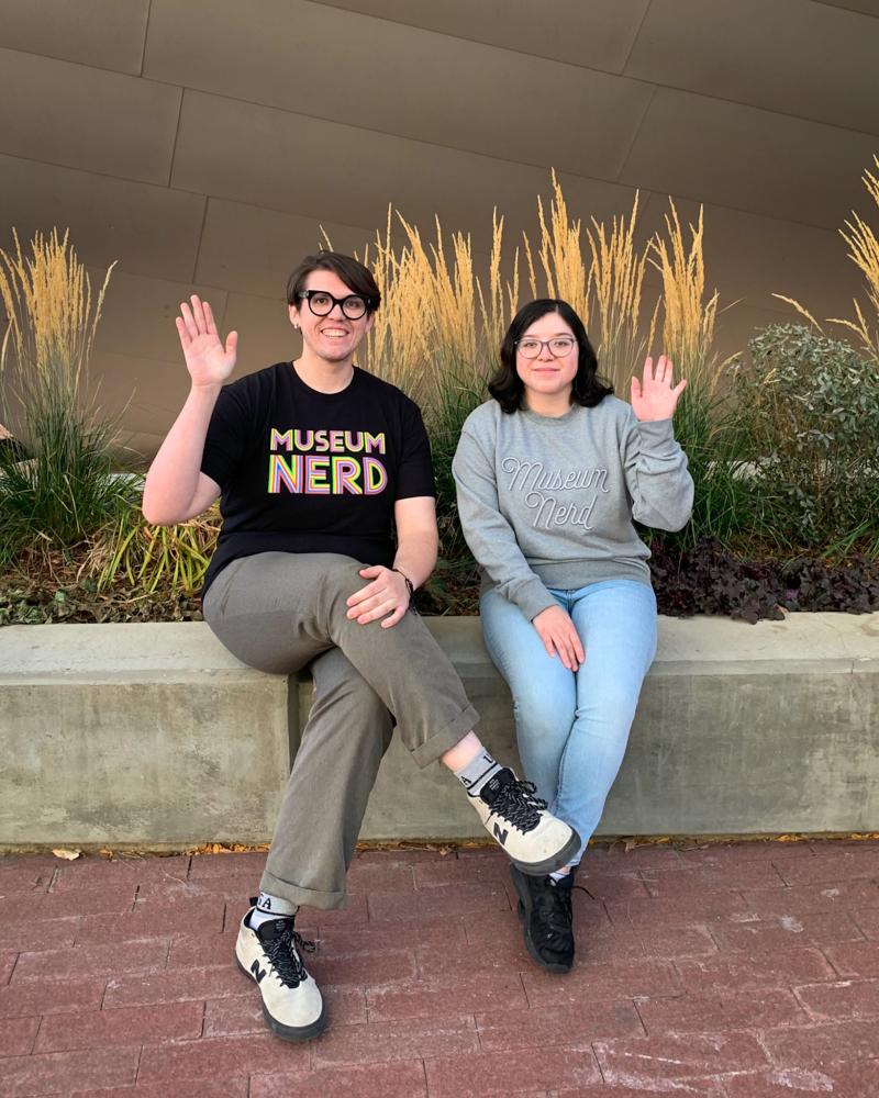 2 Shop employees wearing shirts that say Museum Nerd