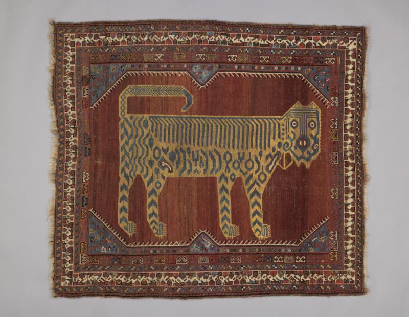 Red patterned Iranian rug with a tiger shape in the center
