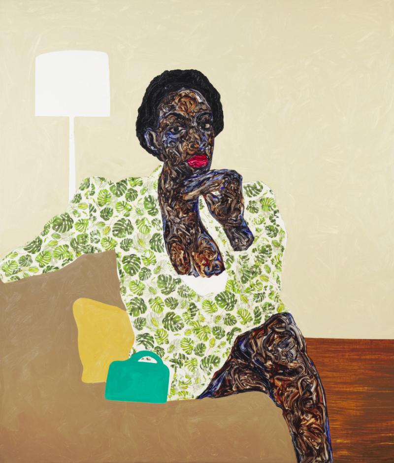 Black woman sitting cross-legged on a couch wearing a green leaf outfit