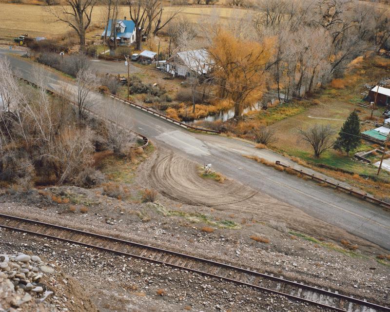 Overhead view of a road and train tracks in a rural small town