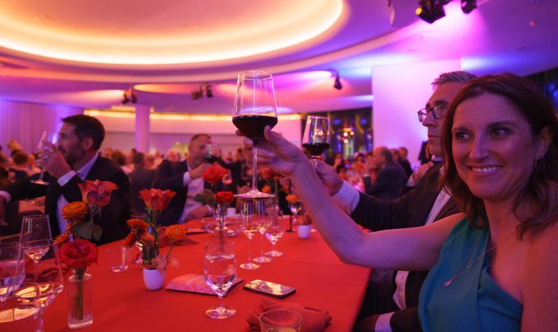 Woman raising her glass of wine to cheers the host