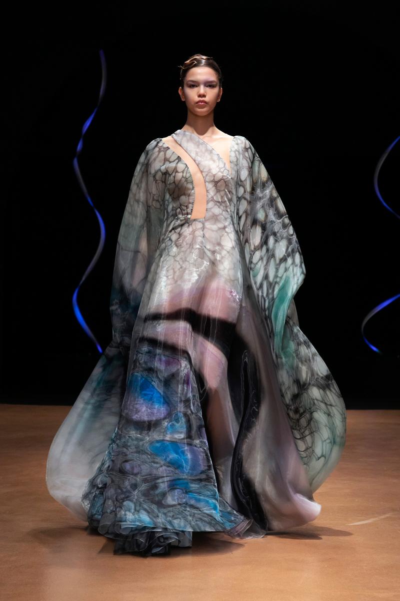 Woman modeling a flowing gown resembling the ocean floor