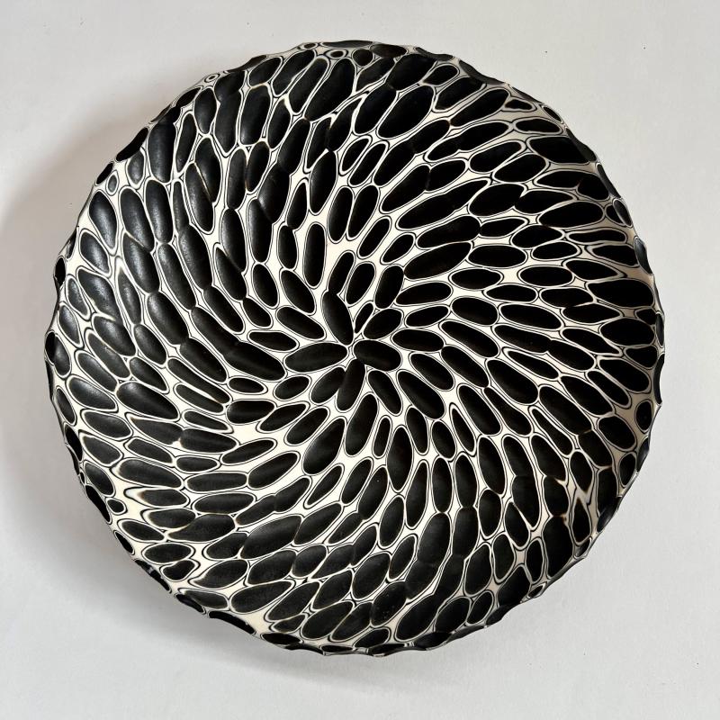 Circular plate with a design of black and white swirls